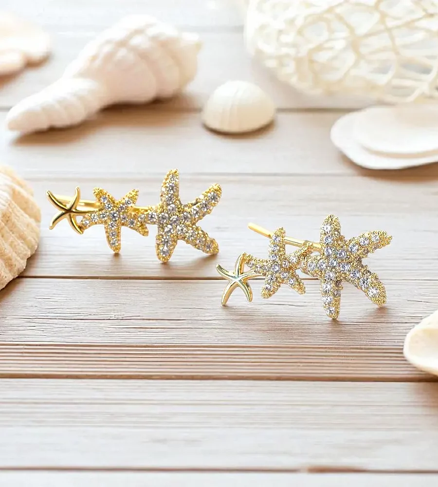 Boucles d'oreilles en acier inoxydable doré pour femme, avec trois étoiles alignée de la plus grande à la plus petite deux ornées de strass et l'autre lisse.