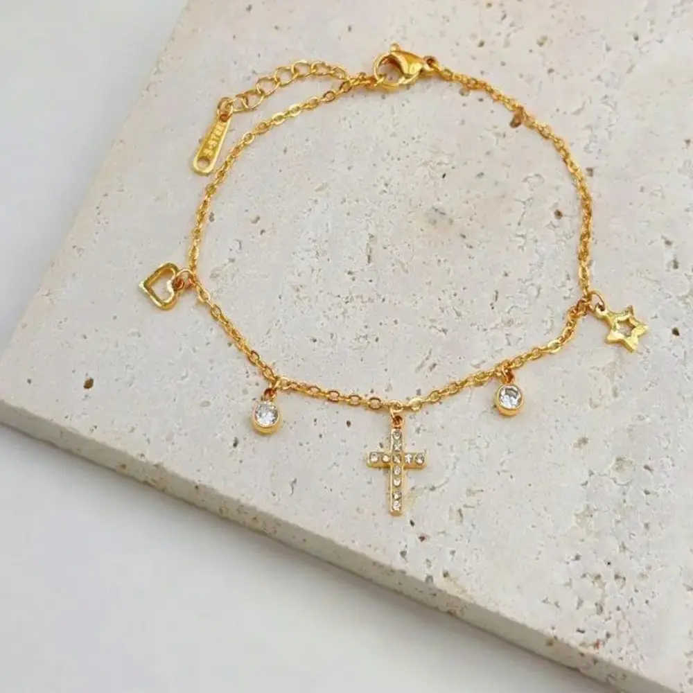 Bracelet avec croix dorée orné de strass et pendentifs cœur et étoile
