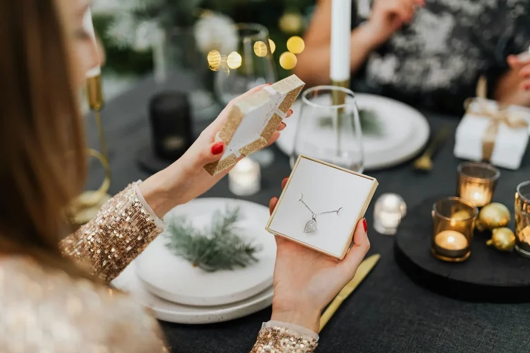 Femme qui ouvre une boite cadeau, un écrin avec un collier